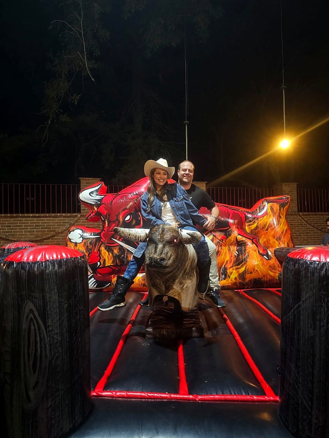 Pareja disfrutando el toro mecánico en un evento nocturno CDMX